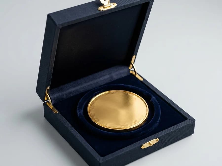 벨벳이 깔린 고급 선물 케이스에 담긴 골드 맞춤 메달 포장 예시